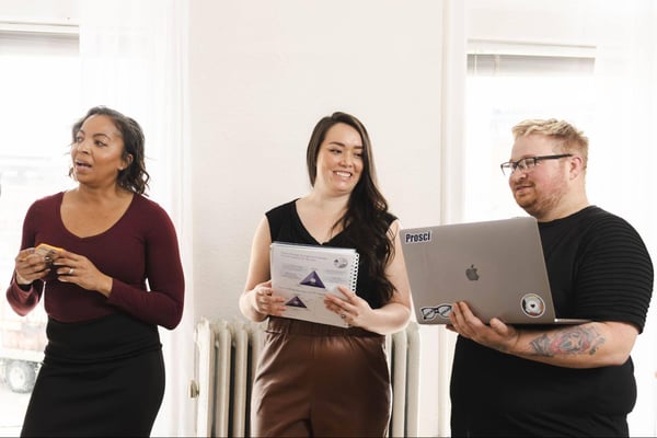 Three colleagues standing together speaking